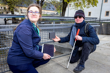  Julia Gesell, Inklusionsbeauftragte der Festung Königstein, und Dr. Jan Blüher, Geschäftsführer des Dresdner Startups visorApps, präsentieren das neue barrierefreie Leitsystem auf der Festung Königstein. Die kleinen Lautsprecher unterstützen blinde und sehbehinderte Menschen bei der Orientierung im Gelände. Foto: Marko Förster/Festung Königstein gGmbH