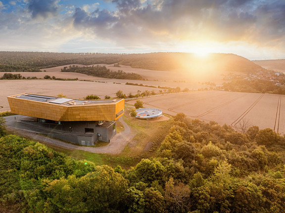 Die markante Kubatur und goldene Farbe des Besucherzentrums „Arche Nebra“ sind von der auf der Himmelsscheibe von Nebra dargestellten Sonnenbarke inspiriert. Foto: Saale-Unstrut Tourismus GmbH, Falko Matte